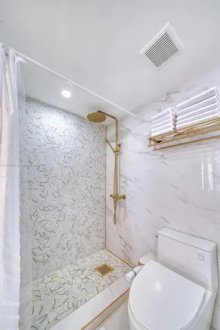 a bathroom with a toilet and a shower