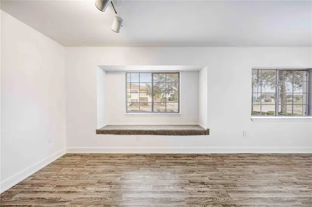 an empty room with a ceiling fan and carpet