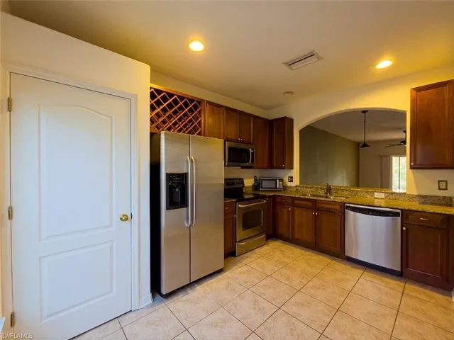 a kitchen with stainless steel appliances granite countertop a refrigerator and a stove top oven