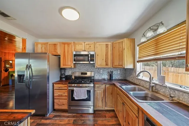 a kitchen with granite countertop a sink stainless steel appliances and cabinets