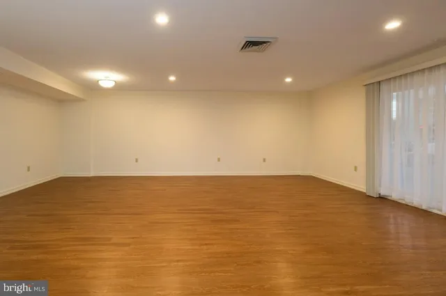 a view of empty room with wooden floor