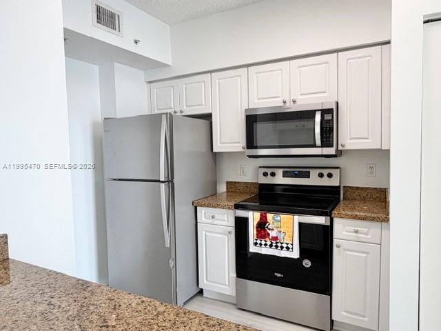 17100 North Bay Road, Unit 1604 Sunny Isles Beach, FL 33160 - Photo 13 of 37 a kitchen with stainless steel appliances a refrigerator stove and microwave