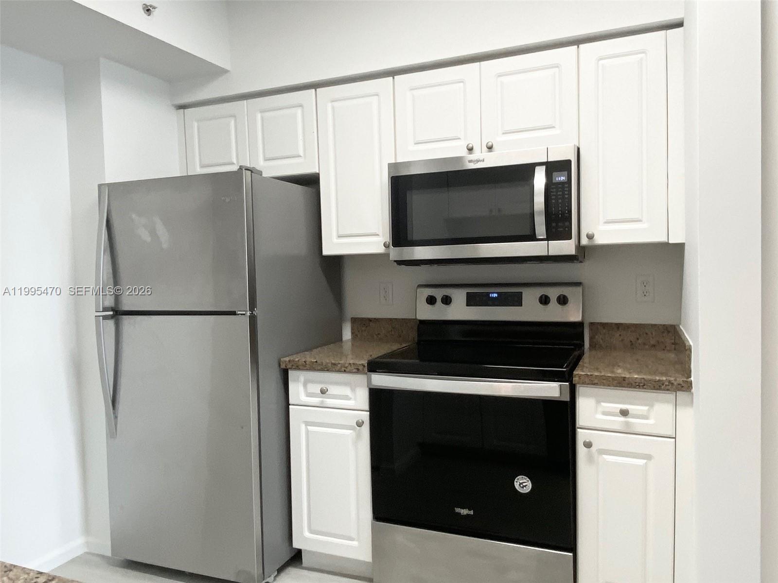 17100 North Bay Road, Unit 1604 Sunny Isles Beach, FL 33160 - Photo 21 of 37 a kitchen with a stove microwave and refrigerator
