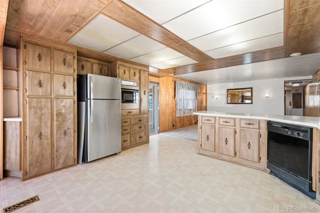 a view of a refrigerator in kitchen and cabinets