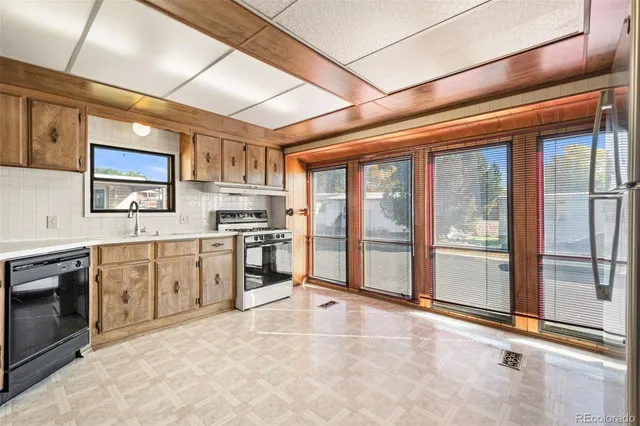 a large kitchen with stainless steel appliances granite countertop a stove a sink dishwasher and a refrigerator with cabinets