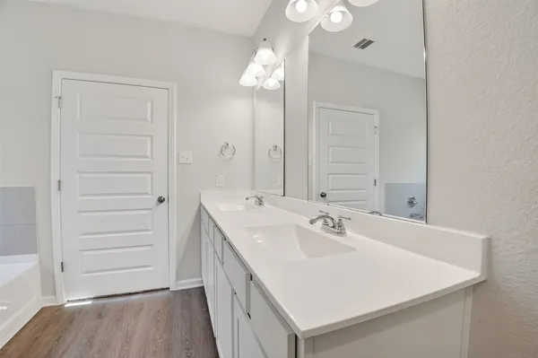 a bathroom with a sink a light fixture and a mirror