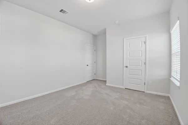 an empty room with windows and closet