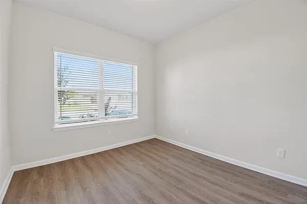 an empty room with wooden floor and a window