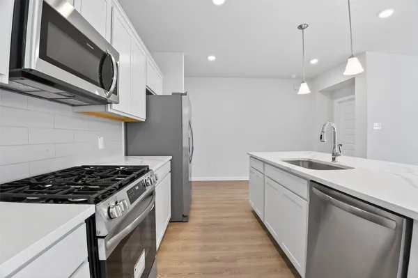 a kitchen with a sink stove and microwave