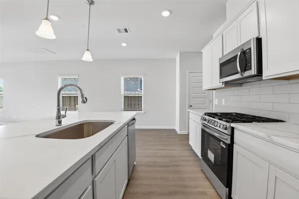 a kitchen with stainless steel appliances granite countertop a sink a stove and oven