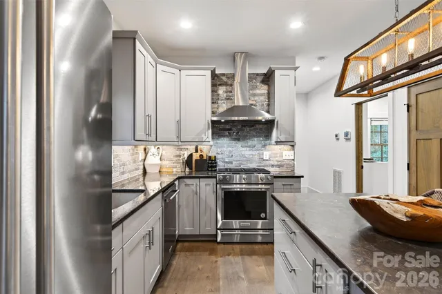 a kitchen with stainless steel appliances granite countertop a stove a sink and a refrigerator