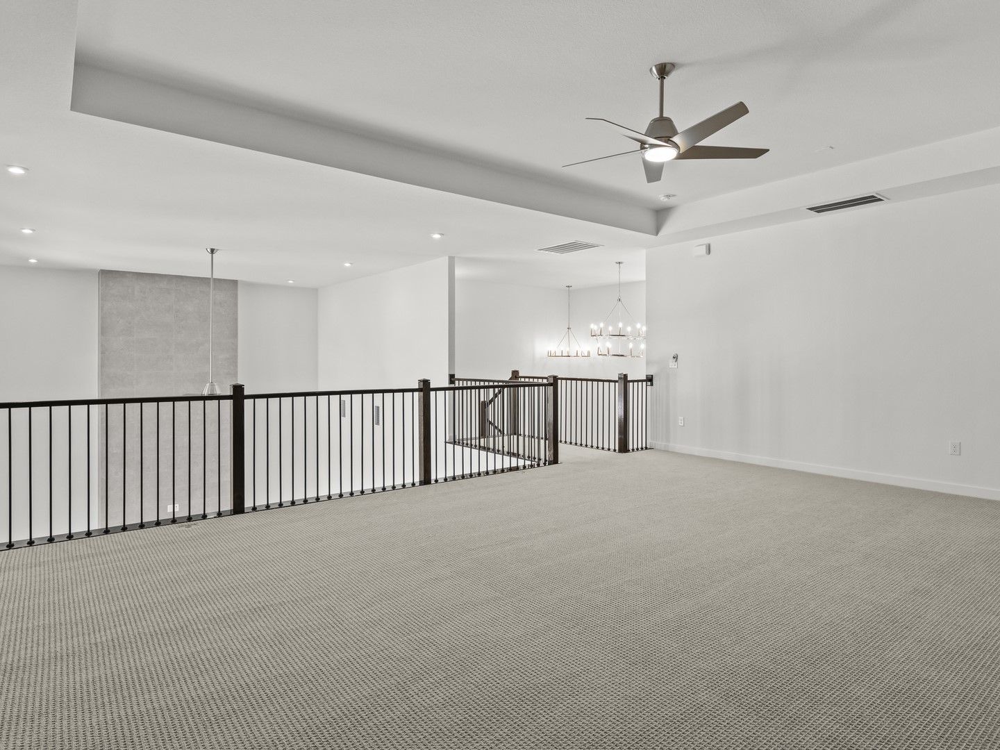 2508 Chiavari Way Leander, TX 78641 - Photo 15 of 24 An airy loft area features neutral carpet and a contemporary chandelier, offering versatile living space.