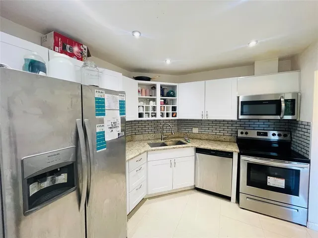 a kitchen with stainless steel appliances a stove microwave and sink