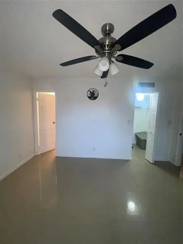 an empty room with windows and cabinet