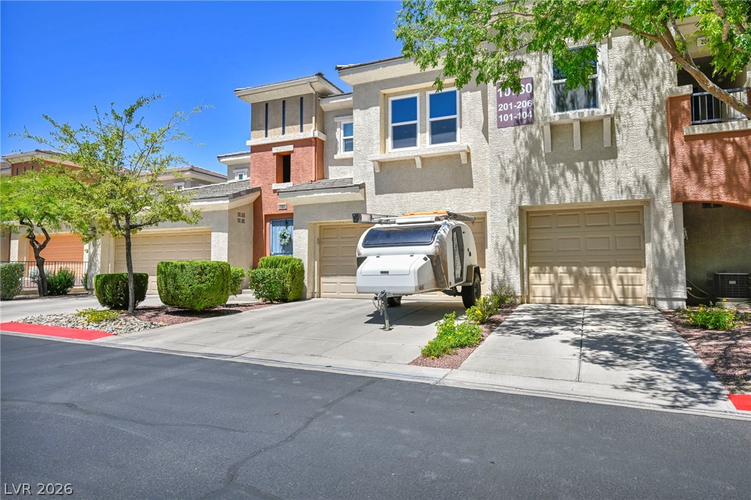 10730 Amber Ridge Drive, Unit 101 Las Vegas, NV 89144 - Photo 32 of 32 A pleasant complex of stucco townhomes with inviting green landscaping and practical attached garages.