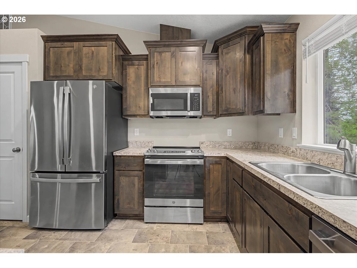 9 North Moolack Way Otis, OR 97368 - Photo 12 of 38 a kitchen with stainless steel appliances granite countertop a refrigerator and a sink