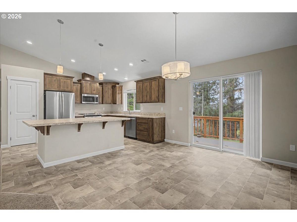 9 North Moolack Way Otis, OR 97368 - Photo 9 of 38 a large kitchen with a large counter top a sink stainless steel appliances and cabinets