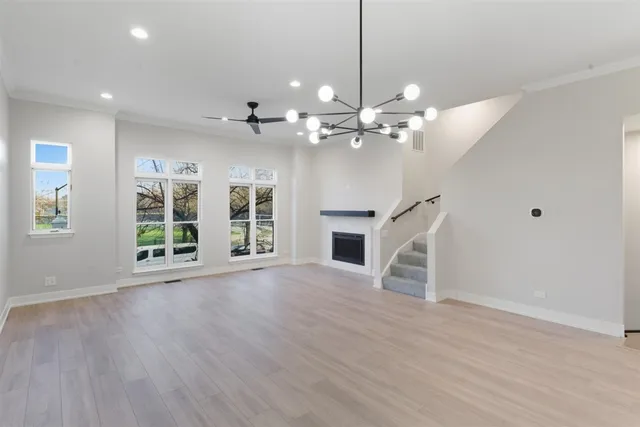 a view of a big room with wooden floor fireplace and windows