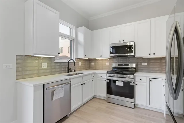 a kitchen with stainless steel appliances granite countertop a sink a stove a microwave and cabinets