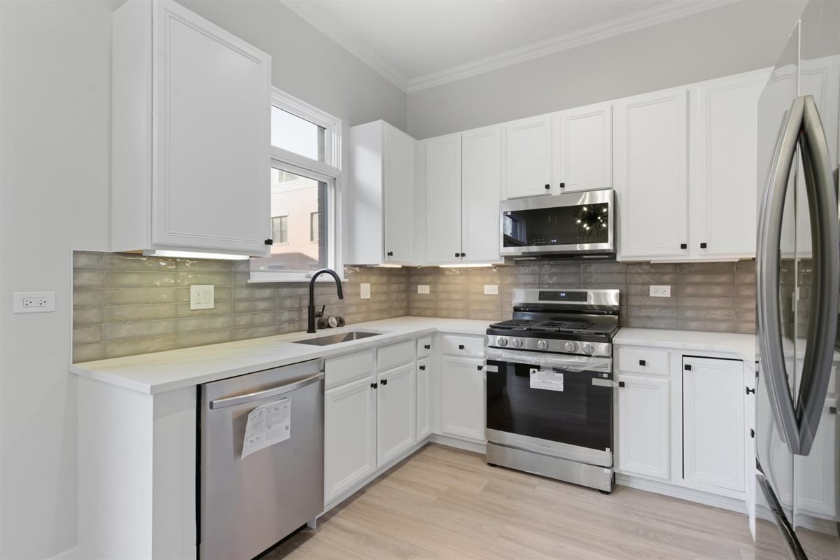 839 West 14th Place Chicago, IL 60608 - Photo 4 of 14 a kitchen with stainless steel appliances granite countertop a sink a stove a microwave and cabinets