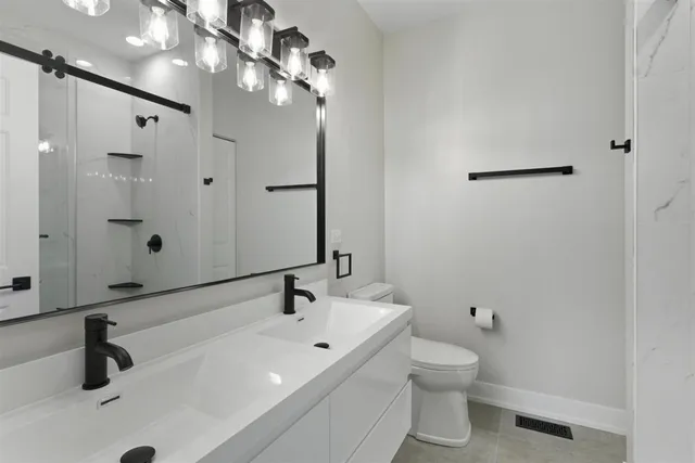 a bathroom with a sink a toilet and a mirror