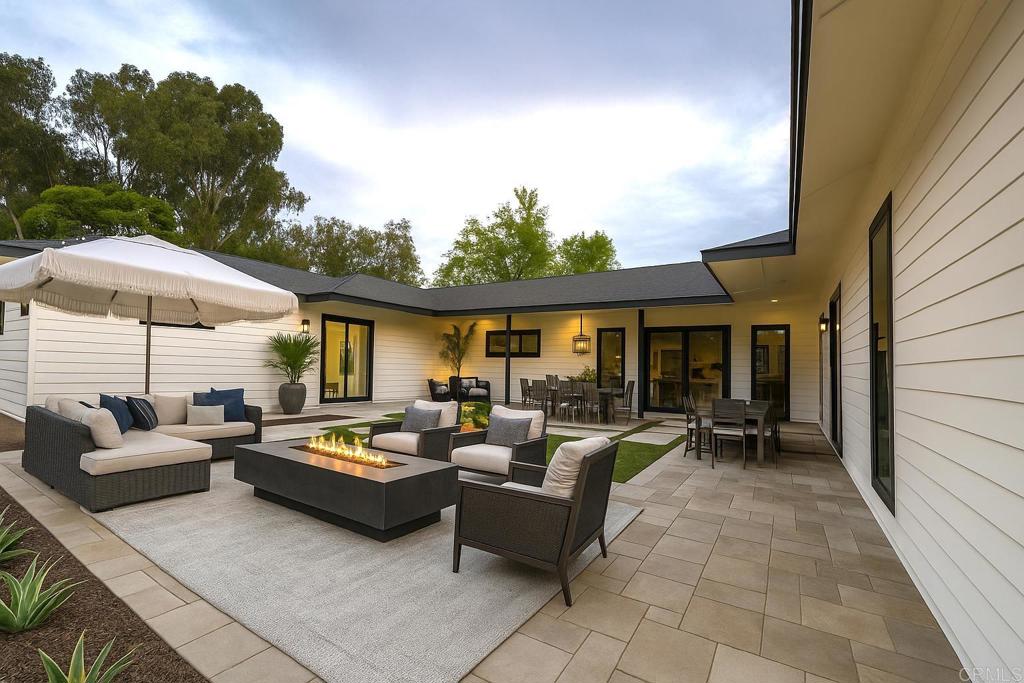 15176 Vali Hai Road Poway, CA 92064 - Photo 3 of 19 a view of a patio with couches table and chairs under an umbrella with a barbeque