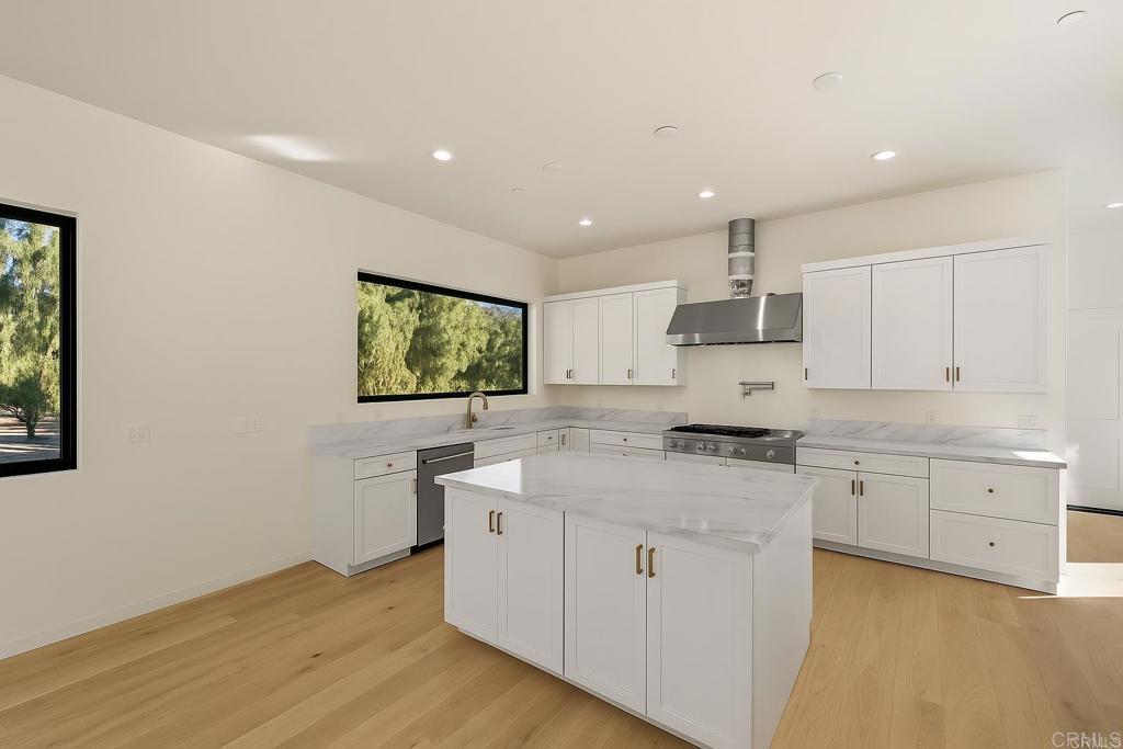 15176 Vali Hai Road Poway, CA 92064 - Photo 9 of 19 a kitchen with a stove a sink a microwave a counter top space and cabinets