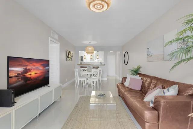 a living room with furniture a chandelier and a dining table