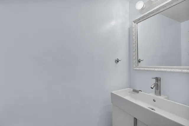 a bathroom with a sink a mirror and vanity