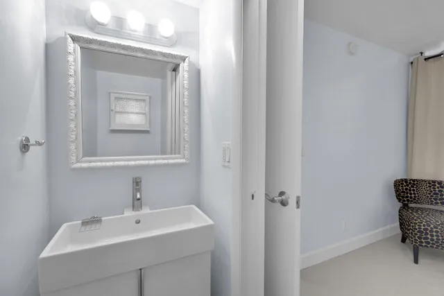 a bedroom with a large bed and a lamp on dresser