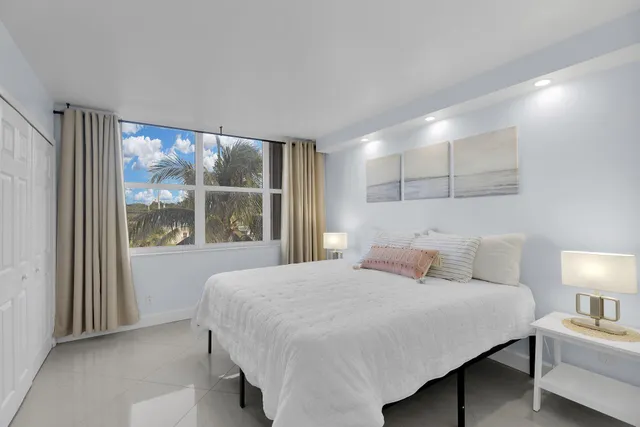 a large bed sitting in a bedroom next to a window