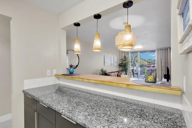 a kitchen with stainless steel appliances granite countertop a sink a microwave a refrigerator and a stove