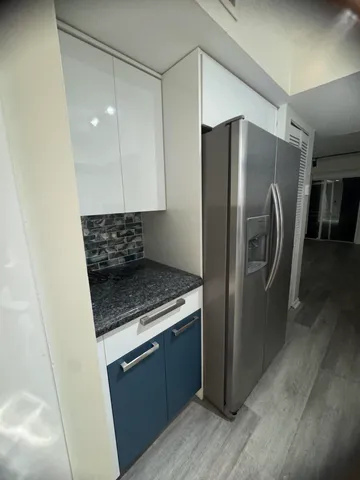 a kitchen with stainless steel appliances granite countertop a refrigerator a stove and a sink with wooden floor