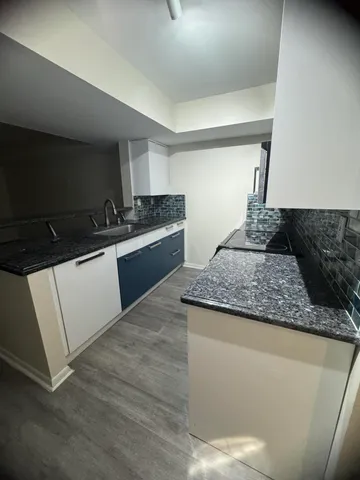 a kitchen with granite countertop a sink and a stove