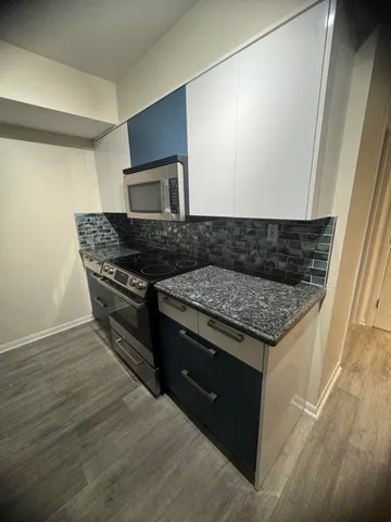 a kitchen with granite countertop a stove and a microwave oven
