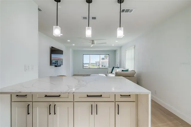 a view of a kitchen with center island and stainless steel appliances
