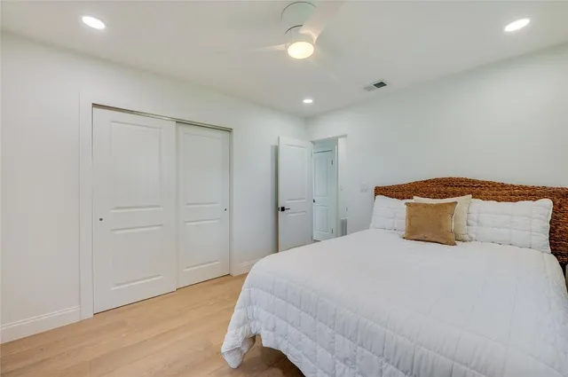 a bedroom with a large bed and wooden floor