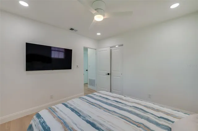 a bedroom with a bed and a flat screen tv