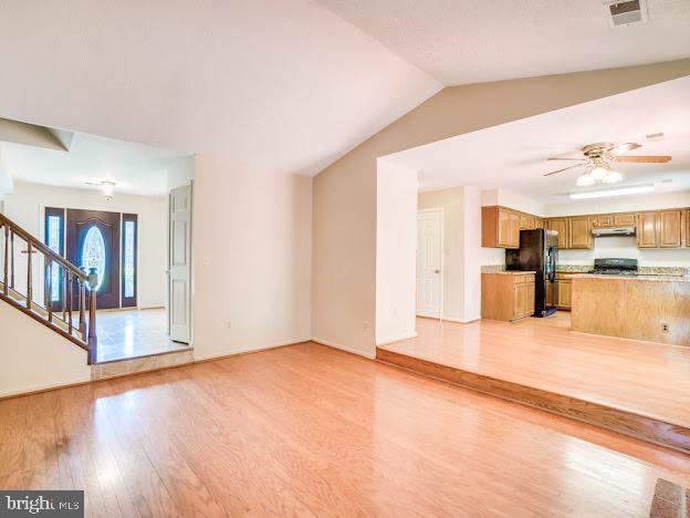 9720 Ironmaster Drive Burke, VA 22015 - Photo 28 of 46 a view of an empty room with wooden floor and a kitchen