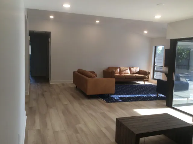 a living room with furniture and a wooden floor