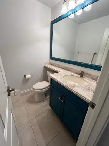 a bathroom with a granite countertop sink a toilet and a mirror