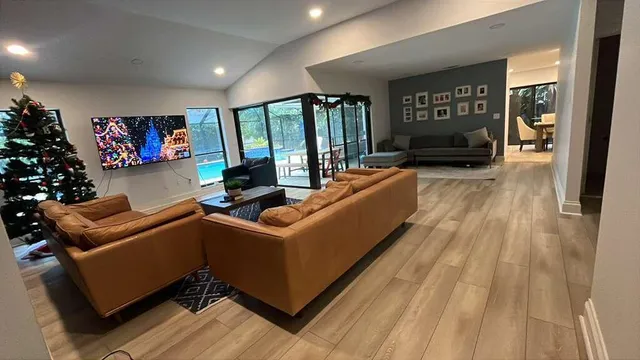 a living room with furniture a flat screen tv and a floor to ceiling window