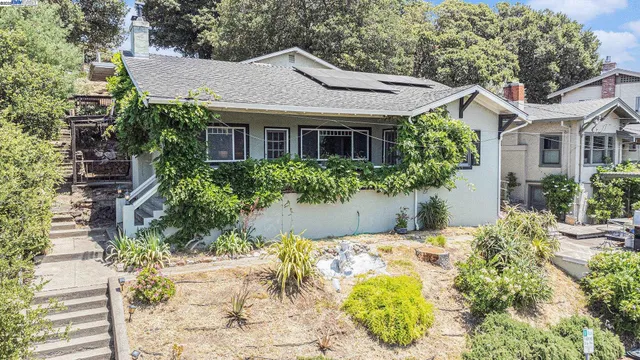 a front view of a house with a yard and potted plants
