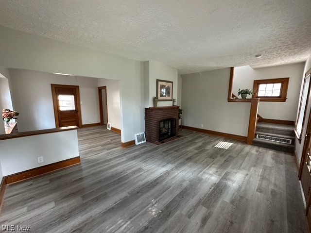 997 Berwin Street Akron, OH 44310 - Photo 8 of 34 Living room with a fireplace, light hardwood floors, a healthy amount of sunlight, and a textured ceiling
