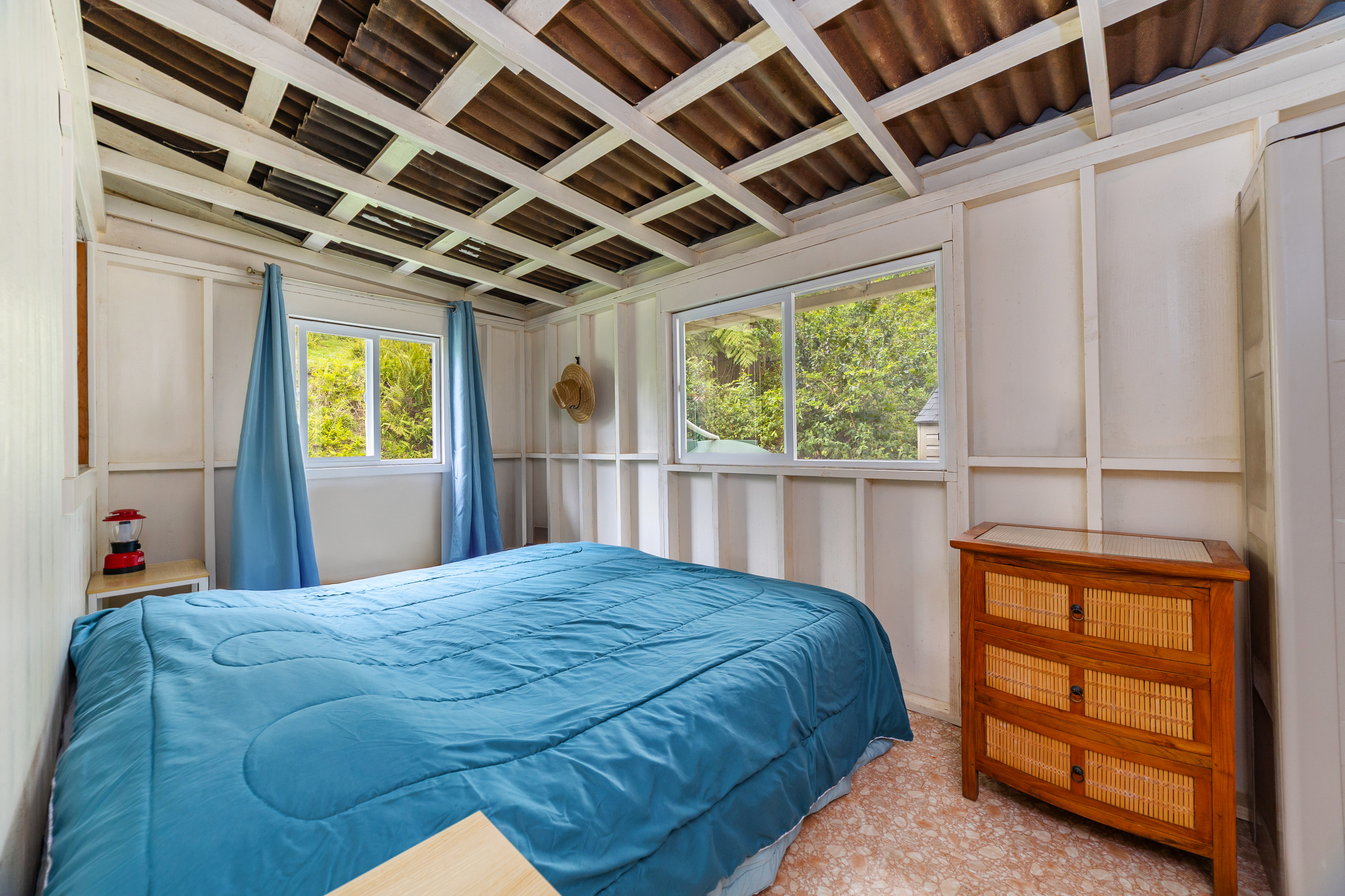 87-1081 Haleili Road Captain Cook, HI 96704 - Photo 11 of 24 a bed sitting in a bedroom next to a window