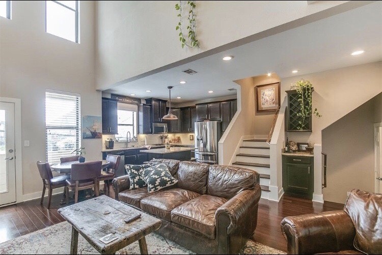 a living room with furniture and a wooden floor