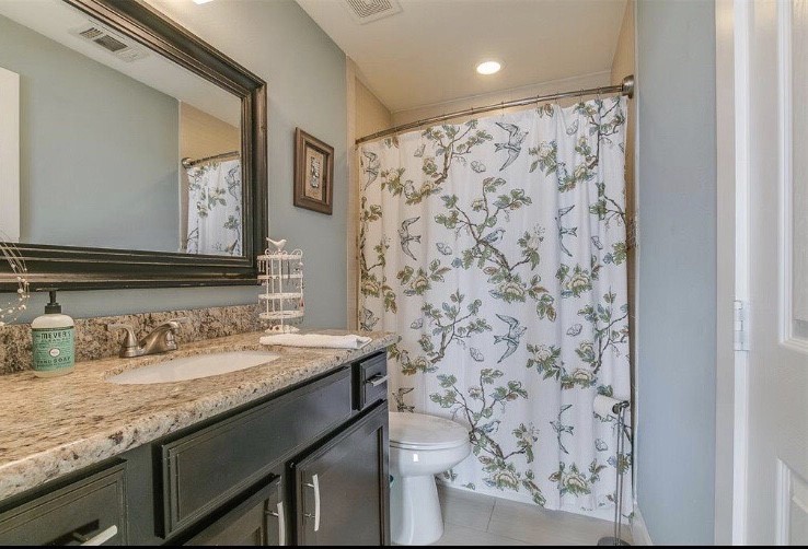 1703 Patterson Street, Unit B Houston, TX 77007 - Photo 14 of 26 a bathroom with a granite countertop sink a mirror and shower curtain