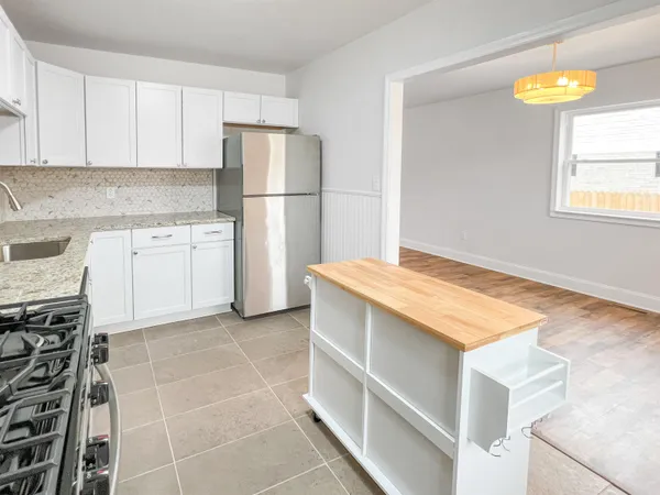 a kitchen with granite countertop a stove and a microwave