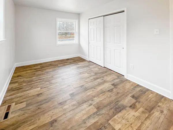 a view of empty room with wooden floor