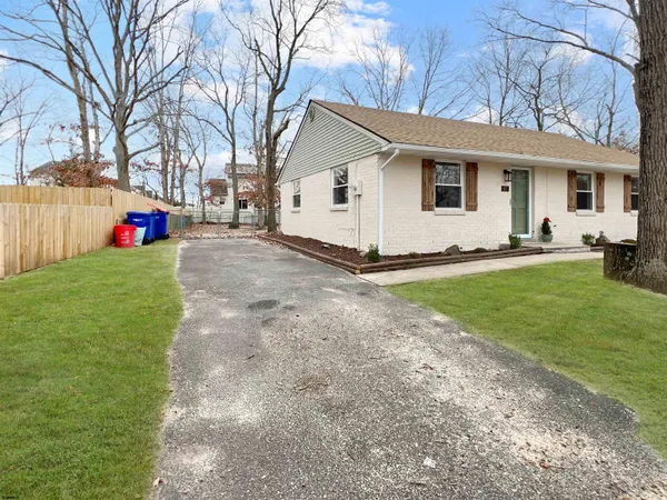 a view of a house with a yard and large tree